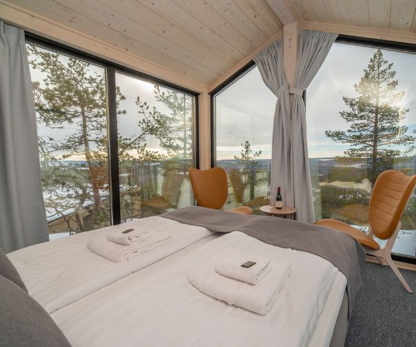 Intérieur lumineux d’une tiny house Doxar House en bois, avec vue panoramique et design scandinave.