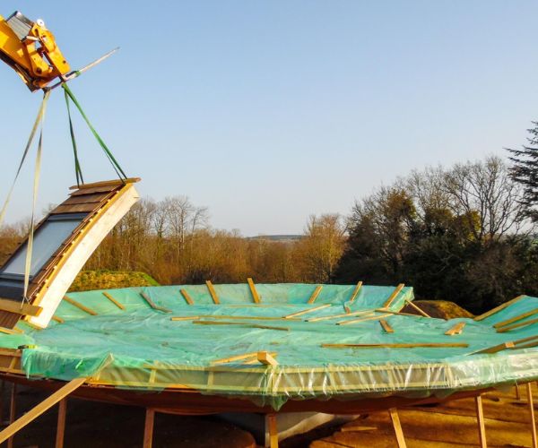 Levage d’un segment de dôme en bois par grue sur chantier Doxar