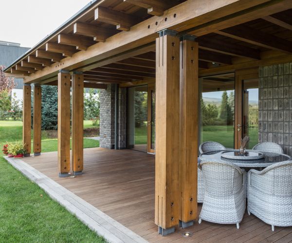 Terrasse couverte en bois réalisée par Doxar, idéale pour les repas extérieurs.
