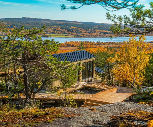 Terrasse panoramique en bois sur une maison design Doxar avec vue sur la nature.
