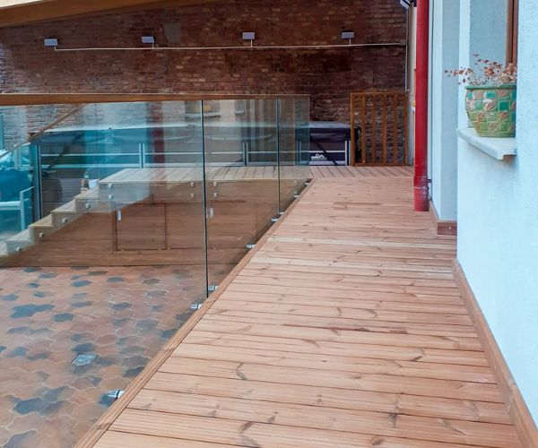 Terrasse bois moderne avec garde-corps vitré réalisée par Doxar.