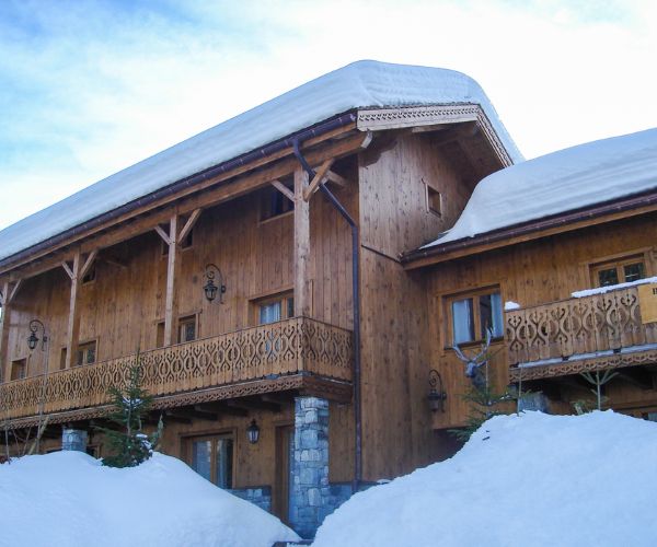 Façade latérale de la résidence bois à Méribel, toitures chargées de neige.
